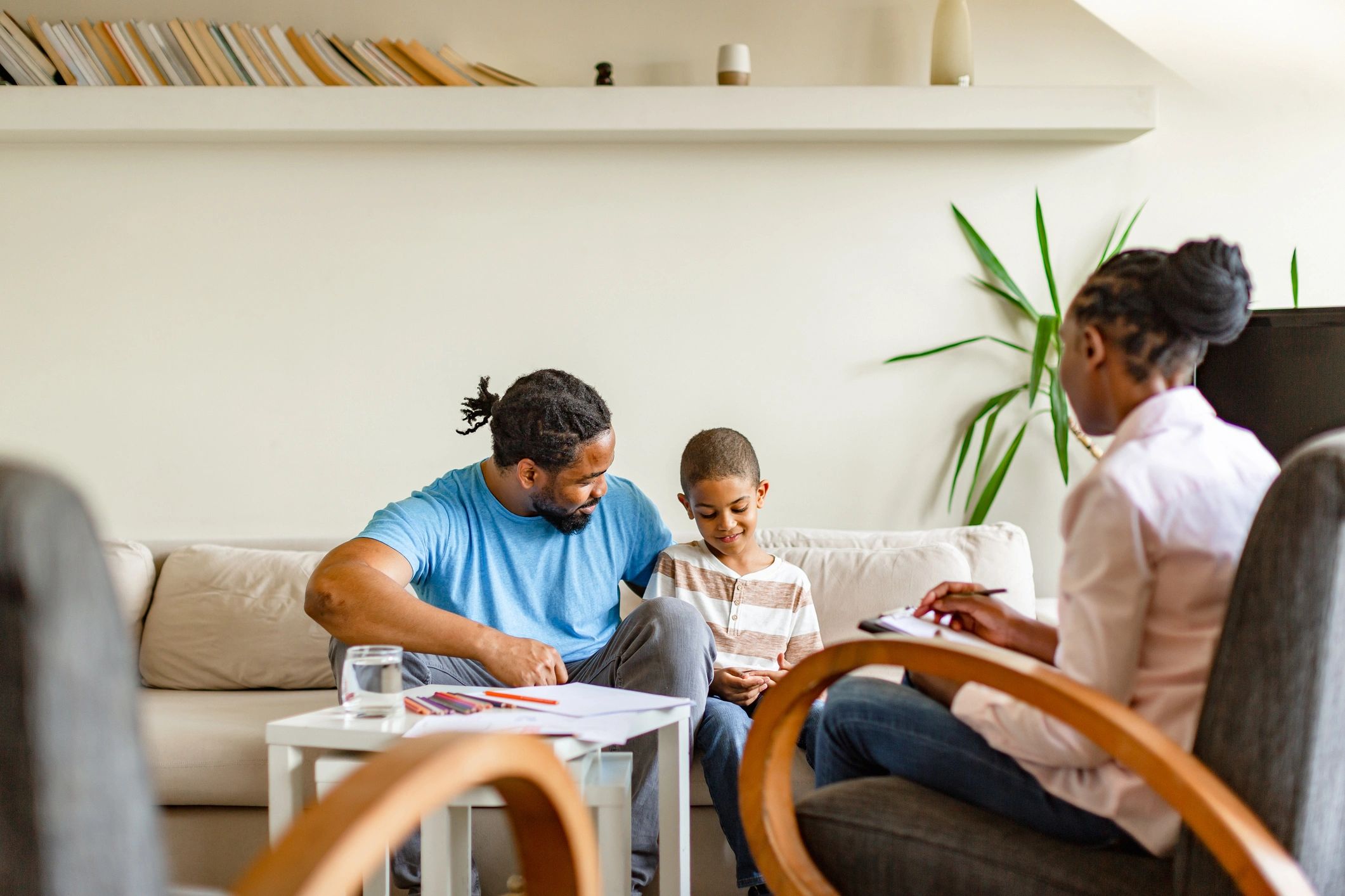 Therapist collaborating with a parent and child during an in-home session