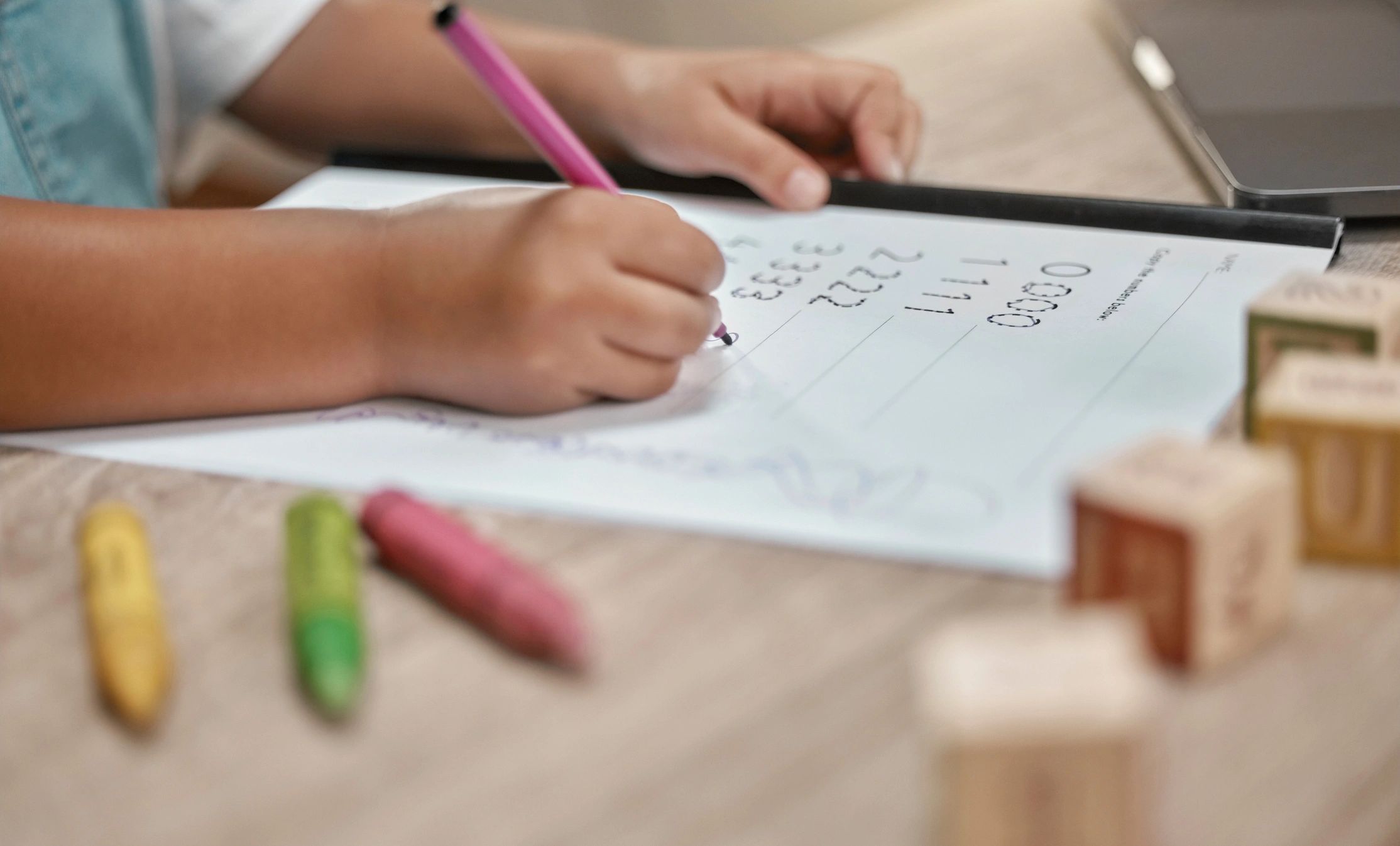 Child practicing handwriting skills with pencil and paper