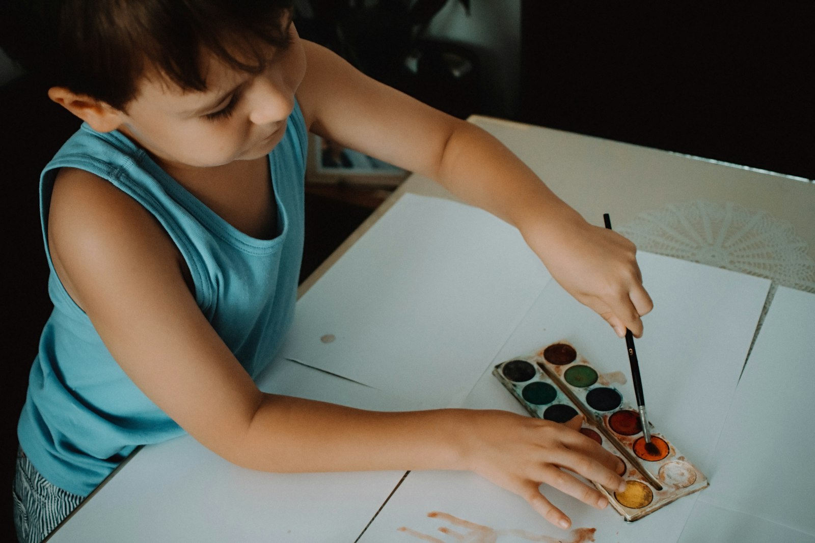 Child exploring sensory play with watercolor paints during therapy